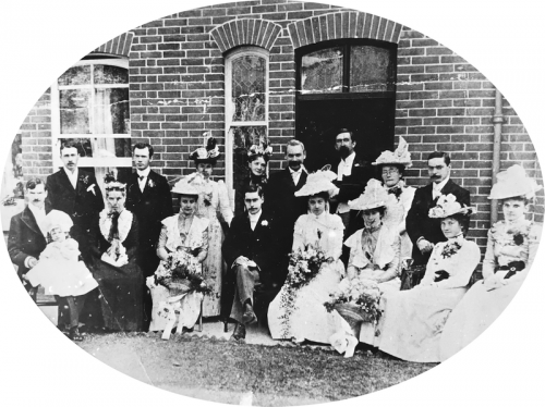 A wedding party gathered outside the front of the house in 1907